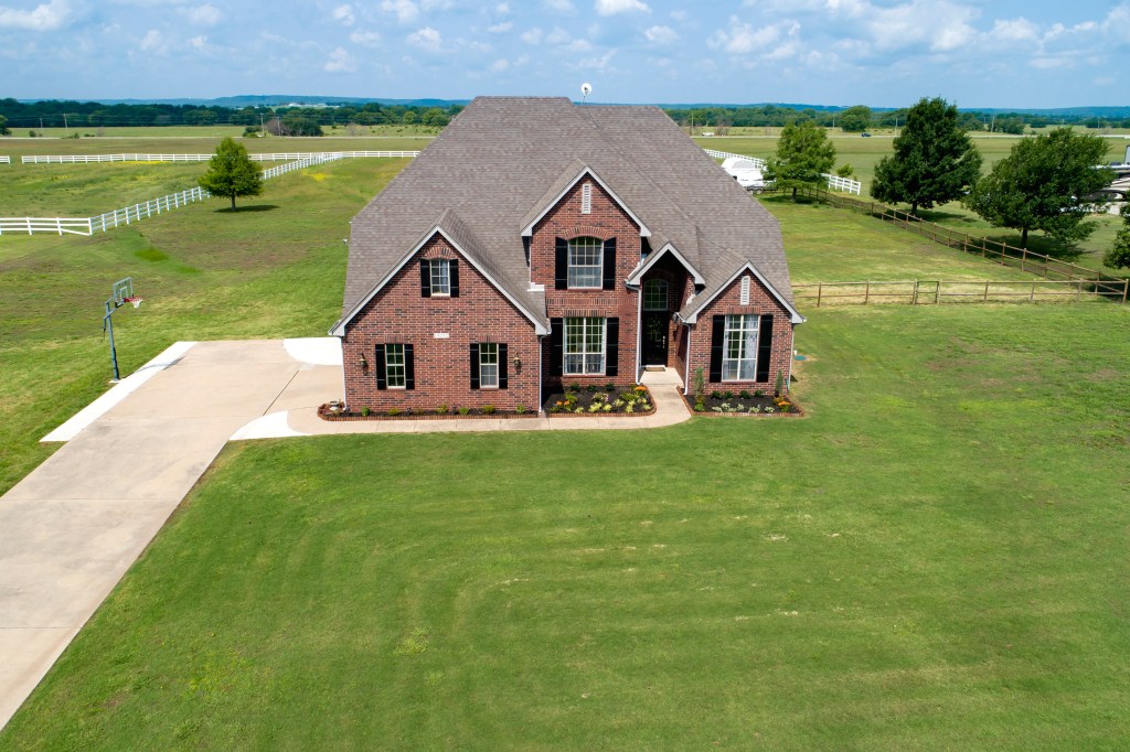 brick house with a large green yard.